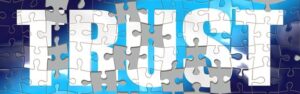 The word TRUST formed by puzzle pieces on blue background